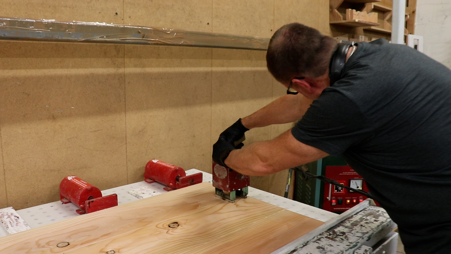 Man pressing a machine into a plank of wood