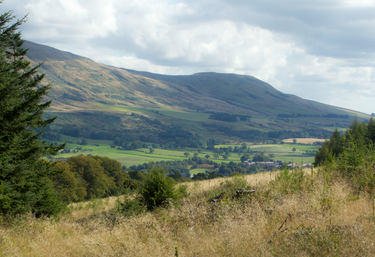A wide glen of fields surrounded by rolling hills